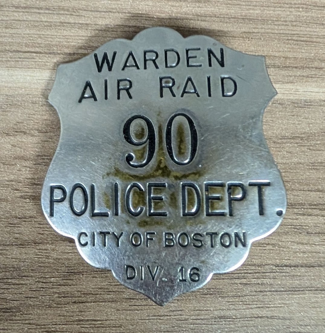 WWII City of Boston Police Department Air Raid Warden Badge Number 90: This is a World War II era civil defense badge issued to an Air Raid Warden by the Boston Police Department. The shield-shaped badge is constructed of silver-tone metal with recessed text and numerals