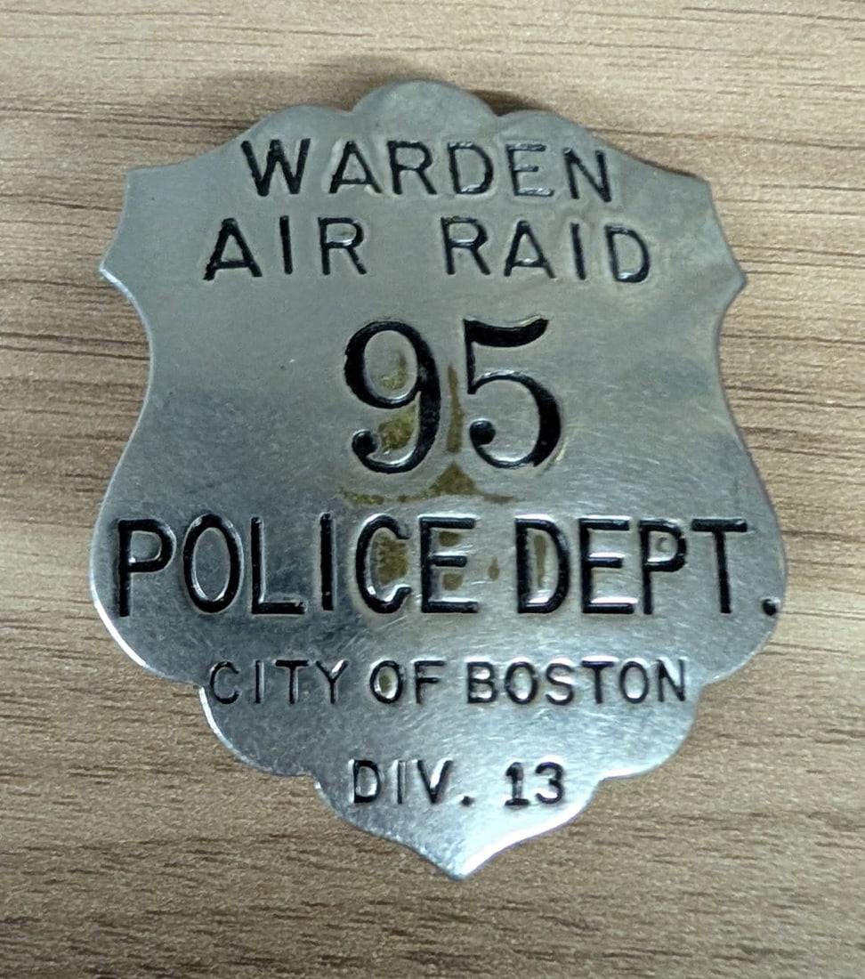 WWII City of Boston Police Department Air Raid Warden Badge Division 13: This is a shield-shaped World War II-era metal badge issued by the City of Boston Police Department for use by the Air Raid Warden service. The badge is constructed from a nickel-silver or chrome-plat