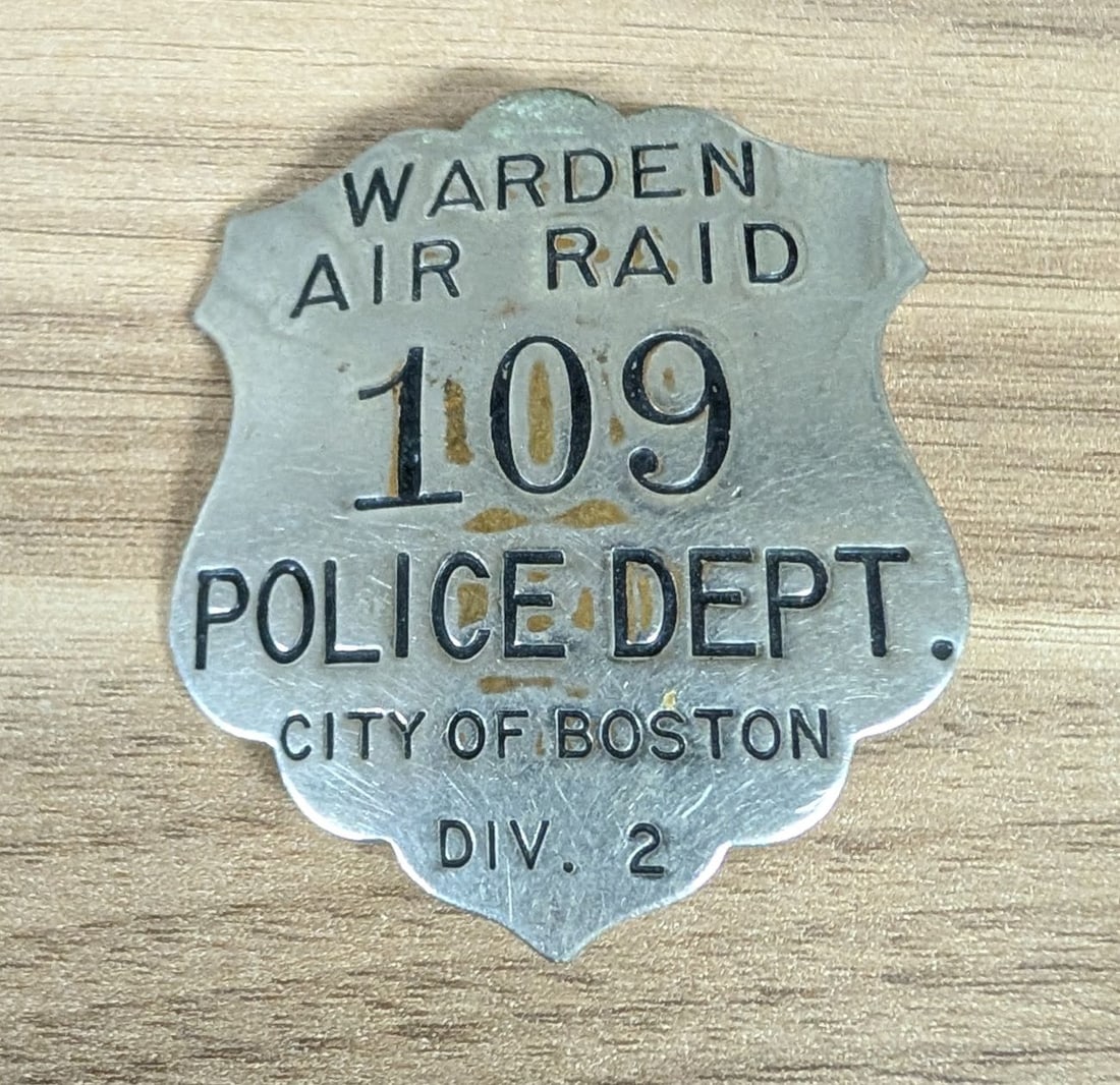 World War II Boston Police Department Air Raid Warden Civil Defense Badge Division 2: A stamped white-metal shield badge issued to civilian volunteers serving as Air Raid Wardens under the Boston Police Department during World War II. The badge features a scalloped edge and recessed le
