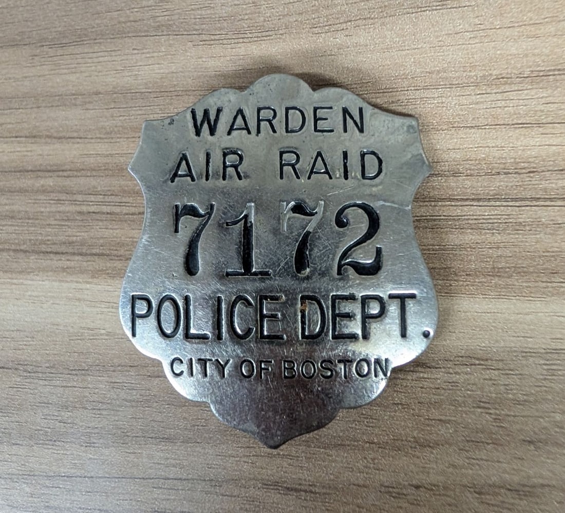 WWII City of Boston Police Department Air Raid Warden Badge Number 7172: This is a World War II era civilian defense badge issued to an Air Raid Warden under the City of Boston Police Department. The badge is constructed from die-struck non-ferrous gray metal alloy, a mate