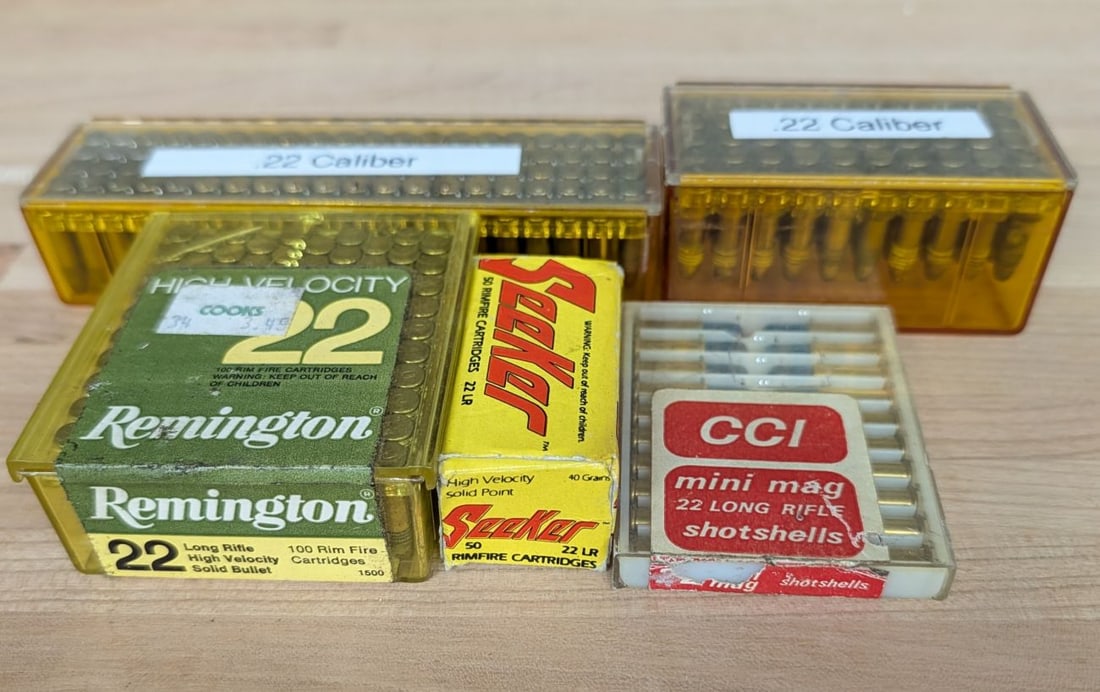 A Lot of 5 Containers of .22 Caliber Rimfire Ammunition: This lot comprises a collection of five containers of .22 caliber rimfire ammunition including various brands and loads. The group features one Remington High Velocity .22 Long Rifle plastic box conta