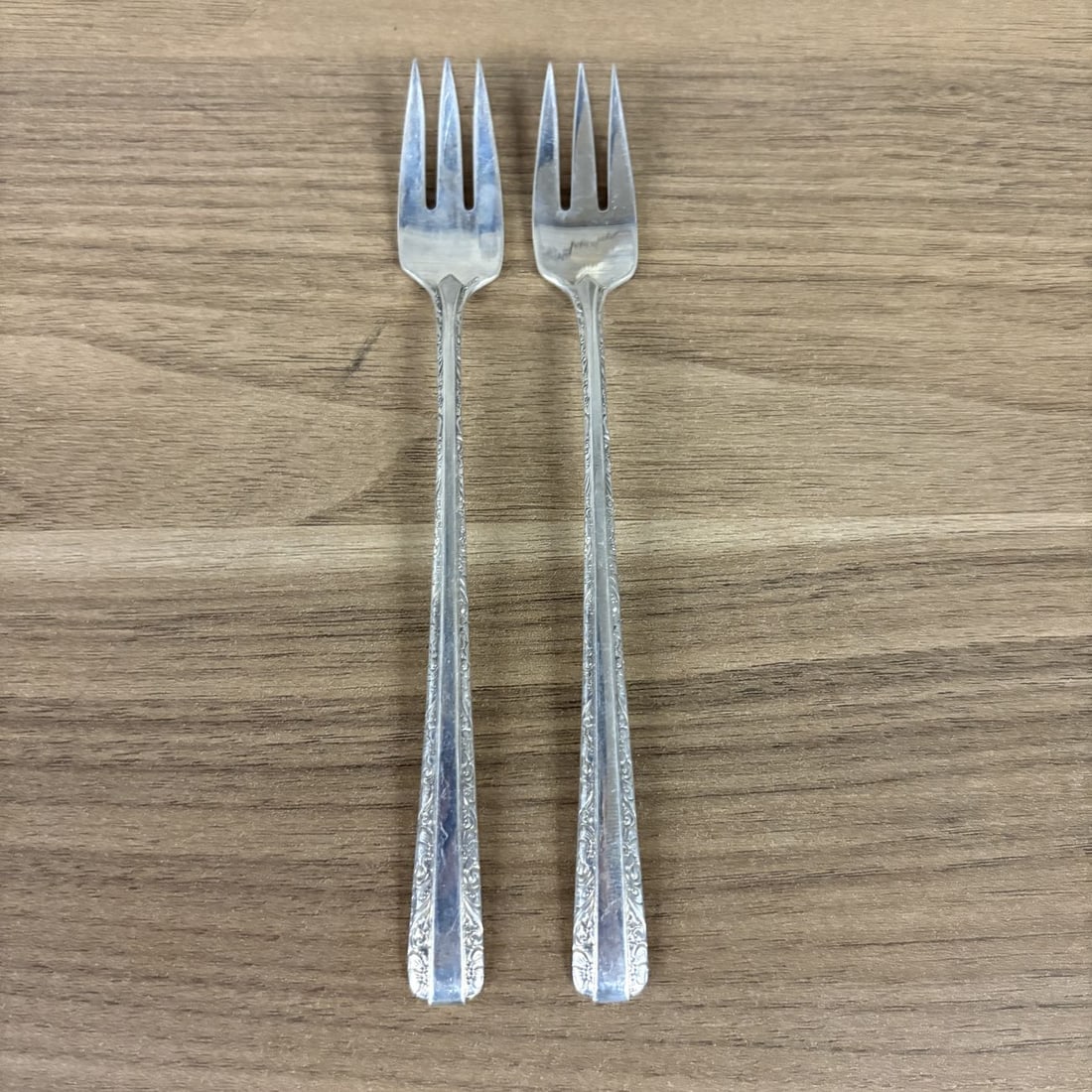 A Pair of Towle Candlelight Pattern Sterling Silver Cocktail Forks: This pair of sterling silver cocktail or seafood forks is produced by Towle Silversmiths in the Candlelight pattern, which was first introduced in 1934. The forks feature a three-tine design and handl
