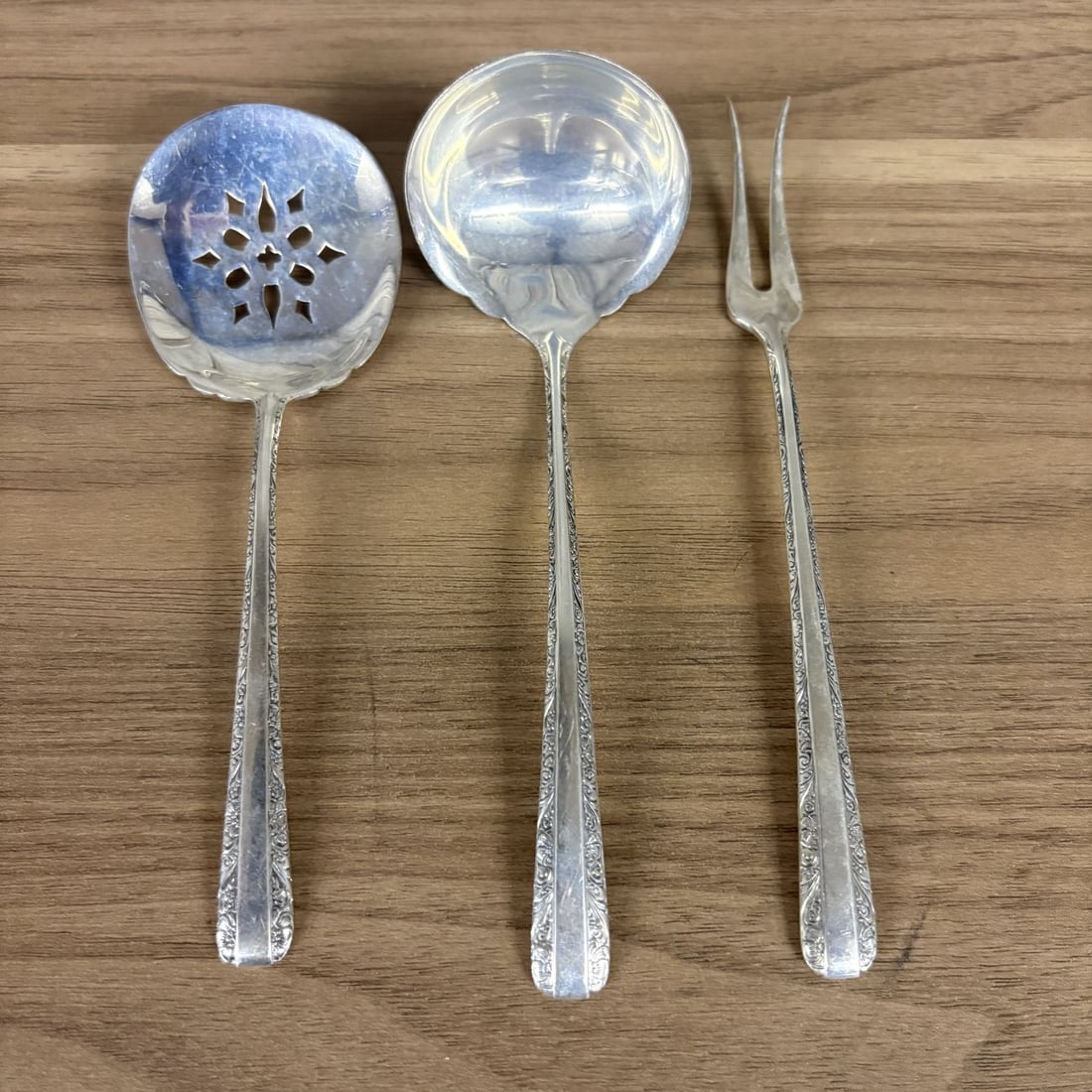 Three Towle Sterling Silver Serving Pieces in the Candlelight Pattern: This three piece sterling silver serving set was produced by Towle Silversmiths in the Candlelight pattern, which was patented in 1934. The collection consists of a cream ladle with a scalloped round 