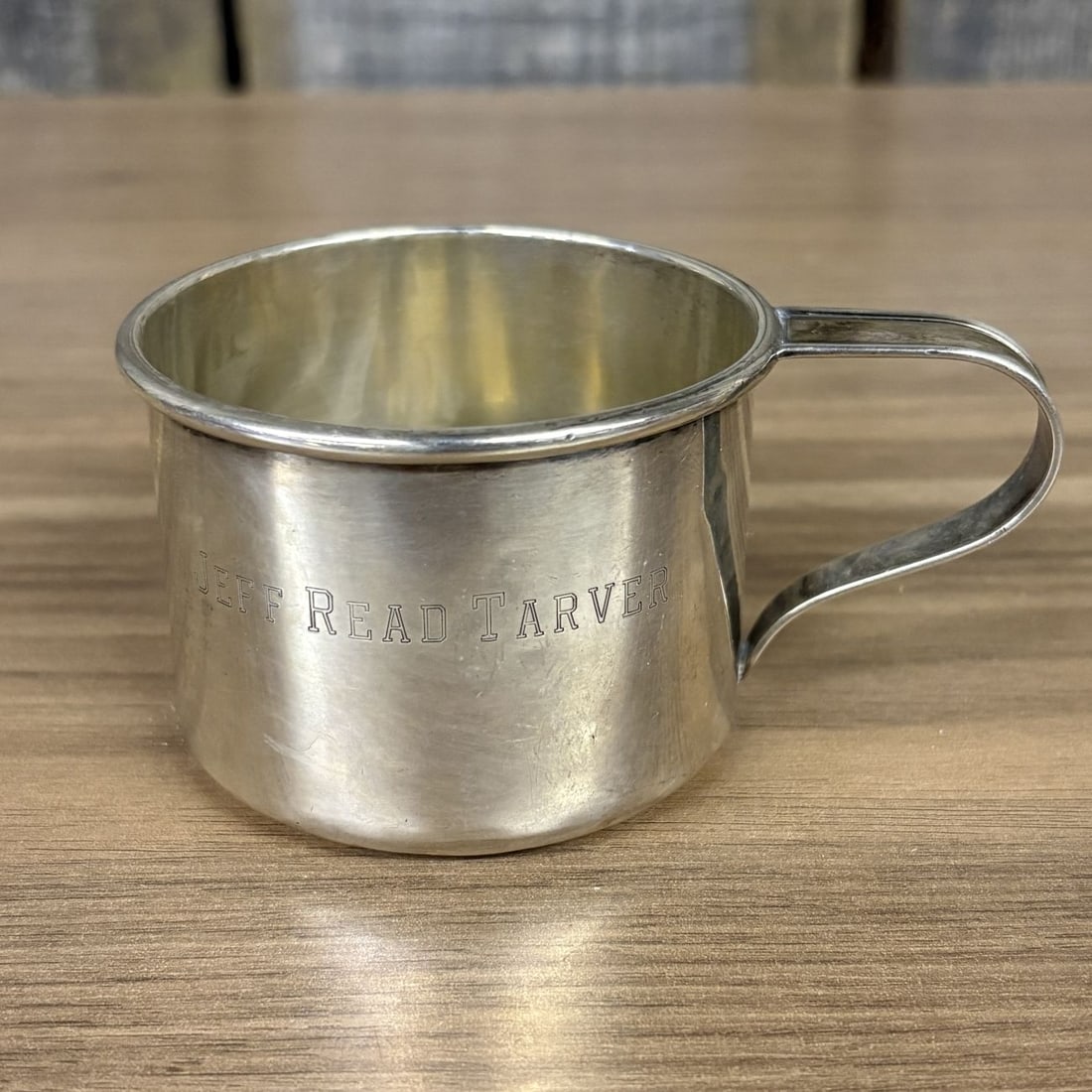 Gorham Sterling Silver Child's Cup Pattern 610: This sterling silver child's cup was manufactured by the Gorham Manufacturing Company of Providence, Rhode Island. The vessel features a cylindrical body with a flared rim and a strap-style handle wit