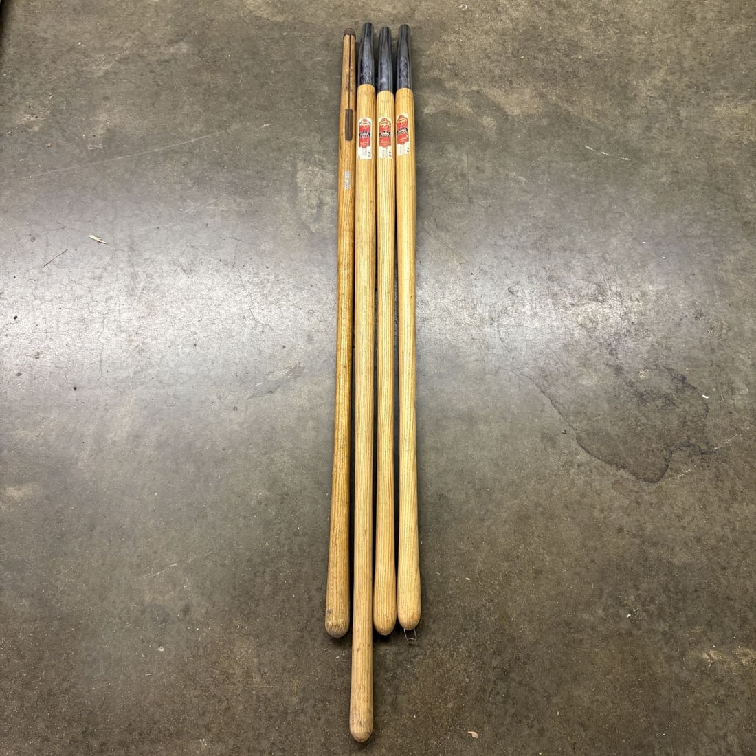 Four Vintage Belknap Blue Grass Hardwood Replacement Tool Handles: A set of four vintage wooden replacement tool handles produced by the Belknap Hardware and Manufacturing Company under the Blue Grass brand. These handles are designed for long-handled agricultural or