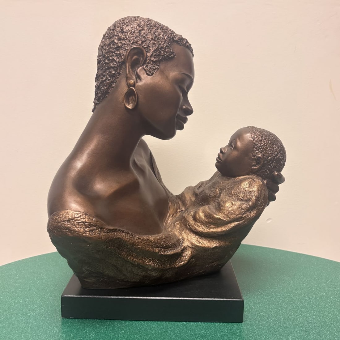 Ecila for Austin Sculpture Treasured Moment Black Mother and Child Figurative Bust: This contemporary figurative sculpture, titled Treasured Moment, is produced by Austin Sculpture and designed by the artist signing as Ecila. The piece is cast in a heavy composite material, such as d