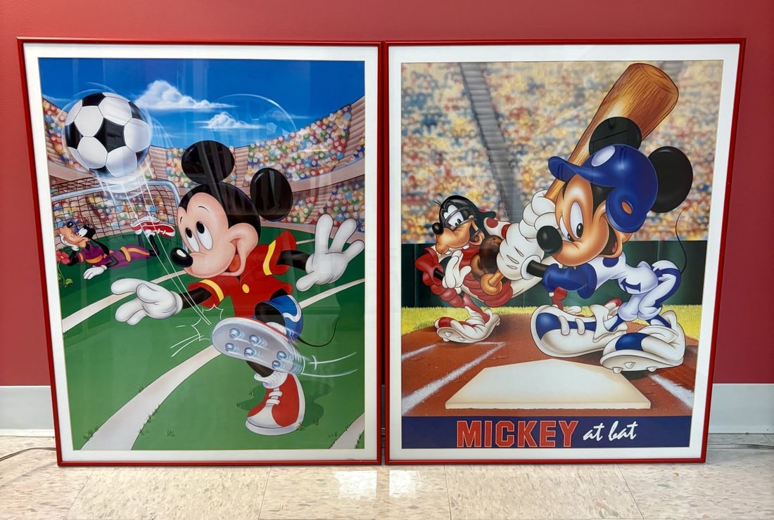 A Pair of Framed Mickey Mouse and Goofy Sports Prints: This pair of matching framed prints features two distinct sports themes starring Mickey Mouse and Goofy. The first print depicts Mickey Mouse dressed in a red and yellow soccer jersey, mid-kick, with 