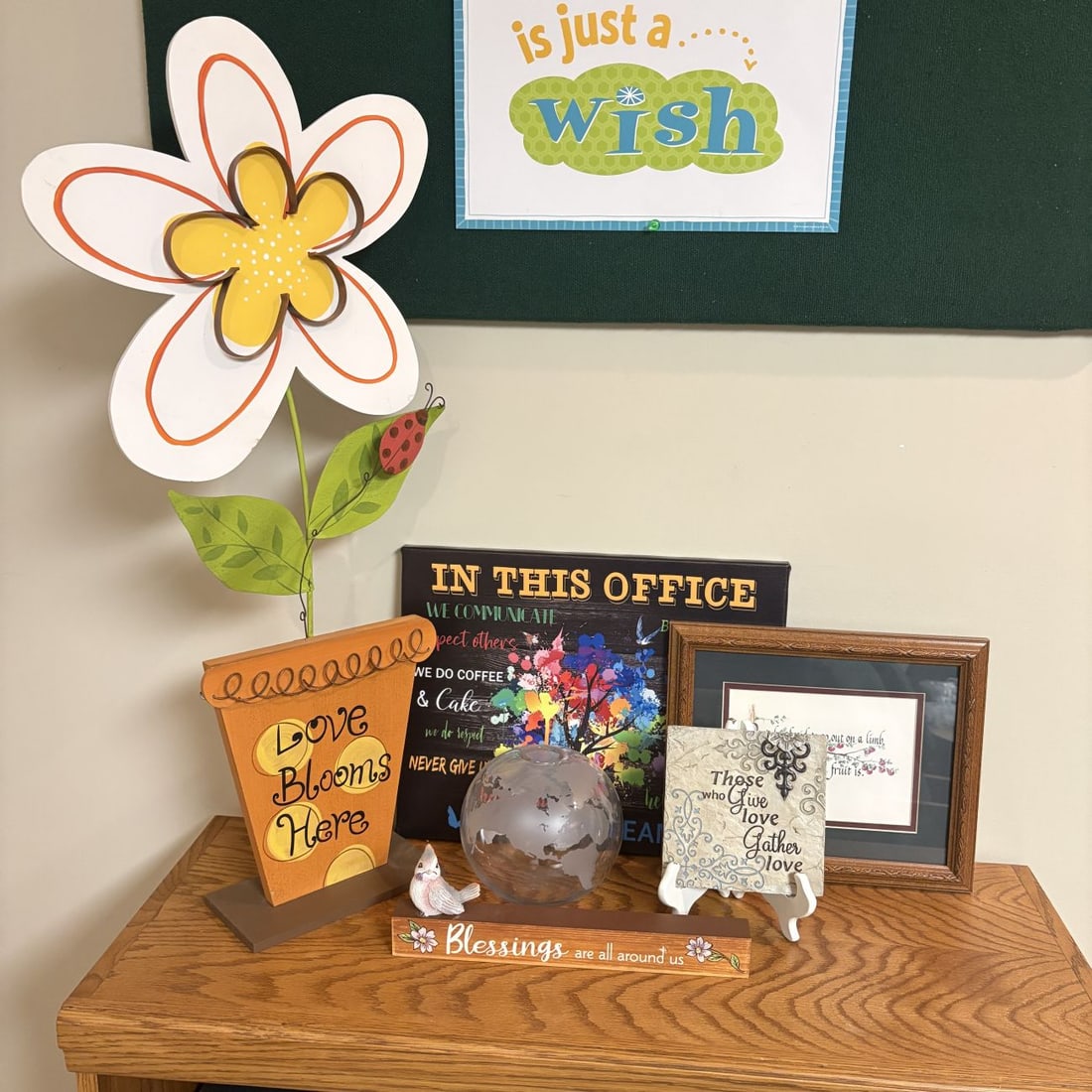 A Collection of Inspirational Home and Office Decorative Items including a Large Metal Flower Stake: An assortment of contemporary decorative pieces featuring motivational themes and colorful designs. The lot includes a large painted metal daisy-style garden stake with white petals outlined in orange