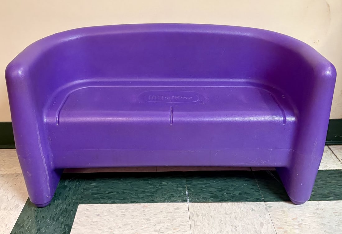 Little Tikes Purple Molded Plastic Child Sized Loveseat: A Little Tikes child sized loveseat manufactured from purple molded plastic. The piece features a chunky, rounded design with a high backrest and integrated armrests. Centered on the seat back is an i
