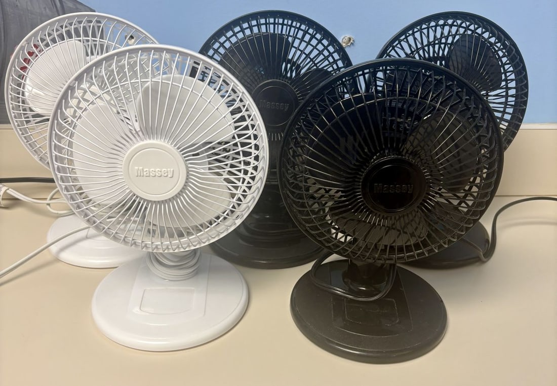 A Set of Five Massey Electric Two-Speed Personal Desk Fans: A set of five Massey compact electric desk fans, comprising three units in black and two in white. Each fan is constructed with a circular plastic base featuring an integrated two-speed rotary switch 