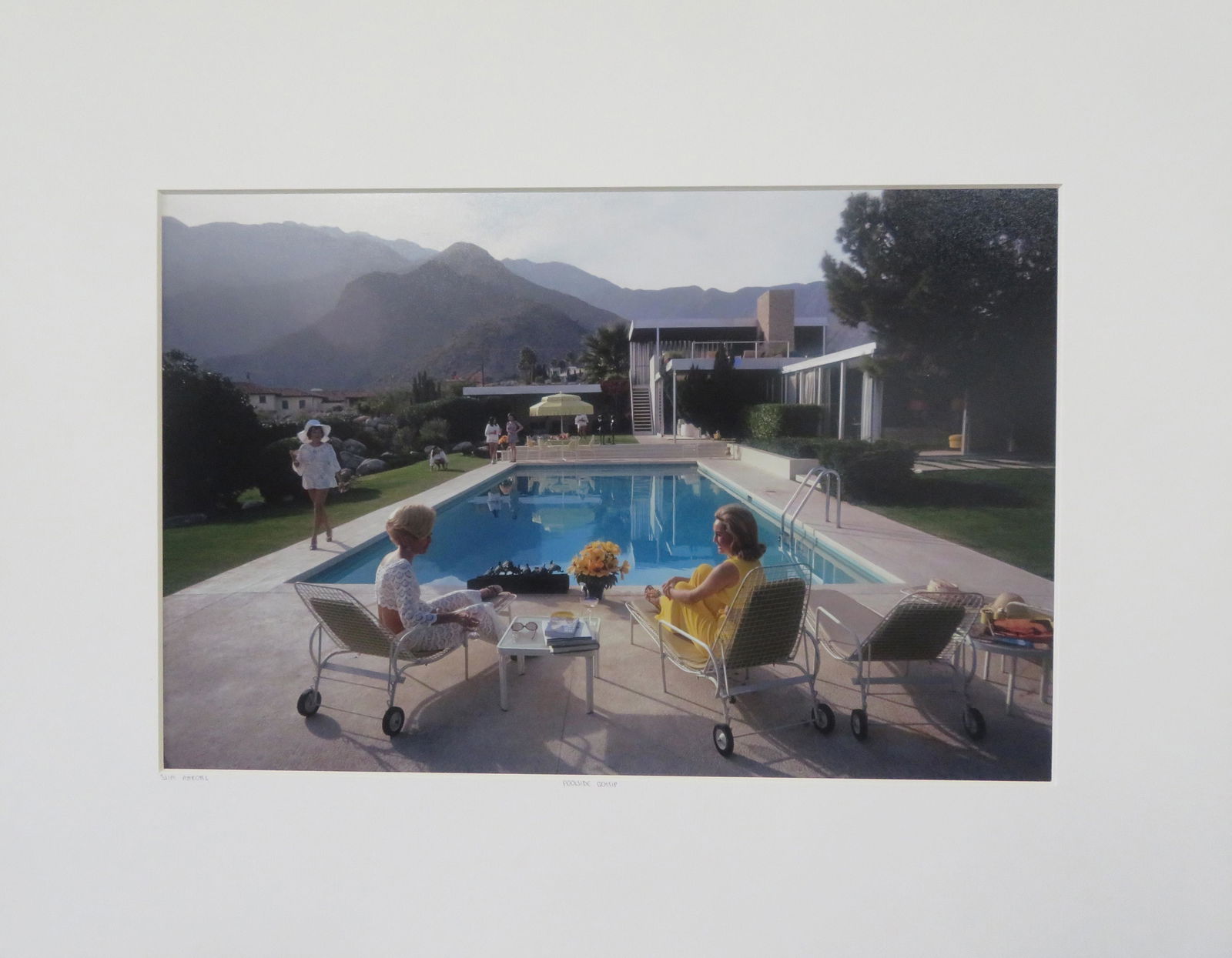 Poolside Gossip by Slim Aarons: Poolside Gossip is Slim Aarons' iconic 1970 photograph of California society women enjoying a leisurely day by the pool. In the foreground, two women are locked in conversation by a sparkling turquois
