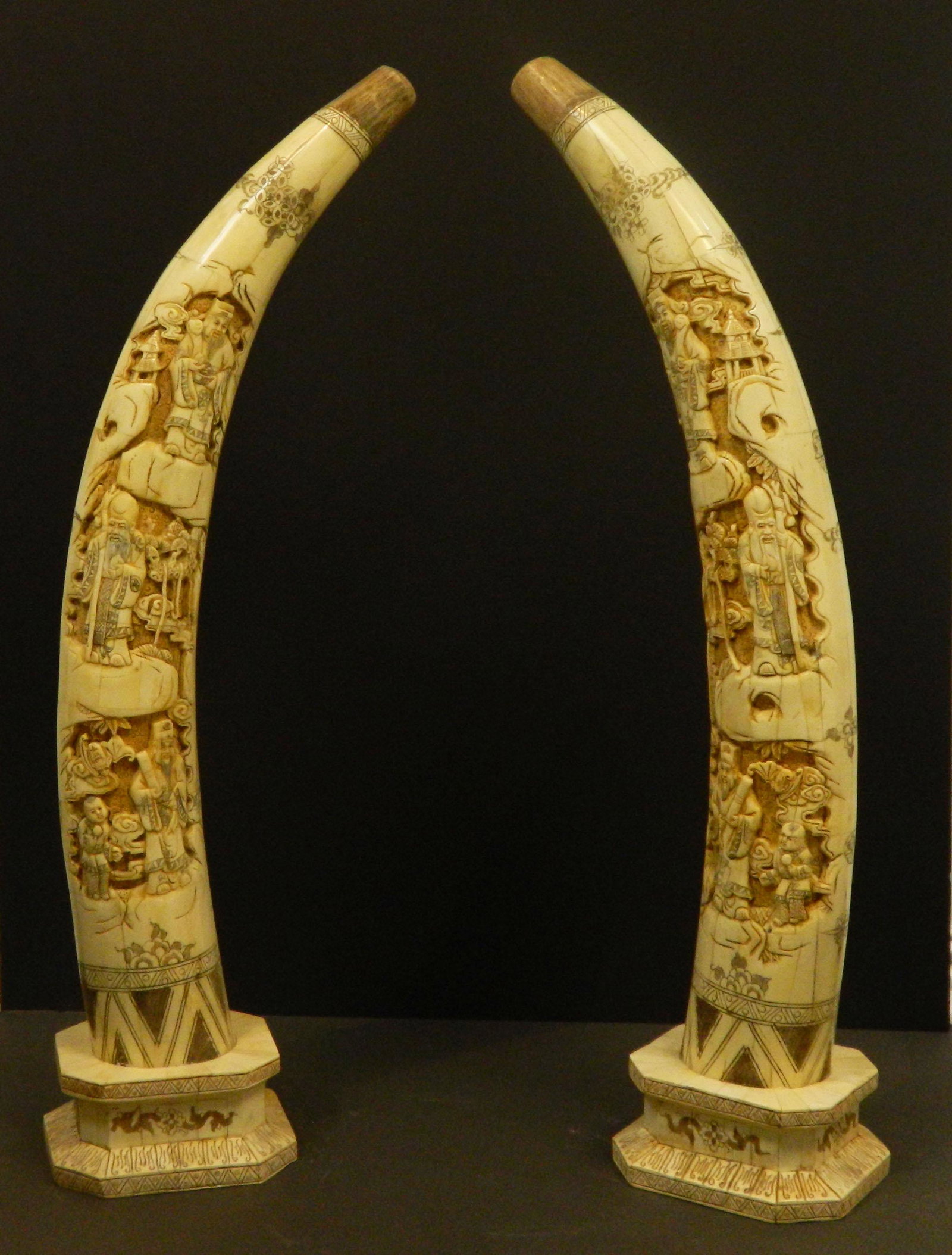 Pair of Small Hand Carved Bone Tusks: Constructed of pieced together and carved cattle bone this pair of hand carved tusks with reliefs and designs stand on beautiful architecturally styled bases of the Han dynasty. These circa 1935 piece