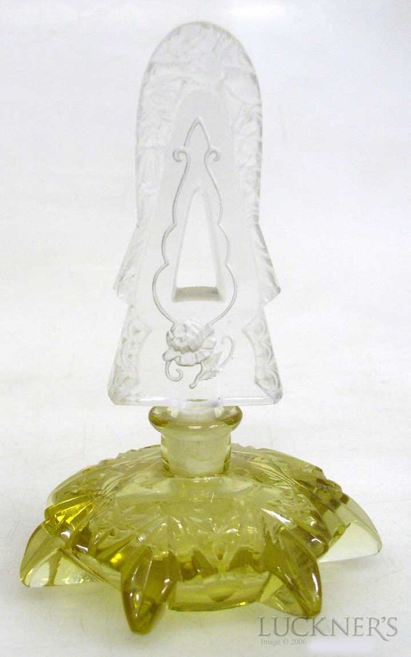 An Art Deco Perfume Bottle: Star-shaped, of topaz-tinted cut glass, with a cut and frosted glass stopper. First half 20th Century. H. 16 cm (6.4 in).