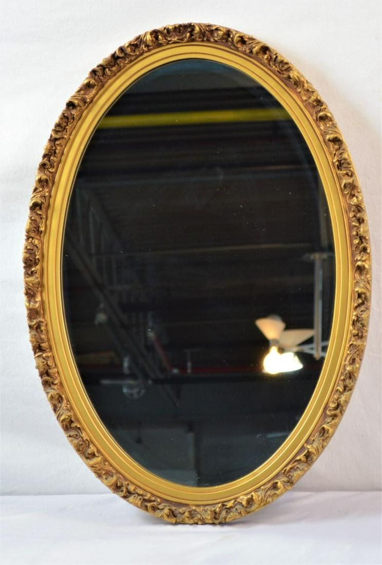 ANTIQUE FRENCH STYLE OVAL MIRROR: Vintage / antique French style oval mirror with floral applied gesso decorative elements and a gold / gilt effect finish. Measure: 26 3/4'' X 18 3/4'' Provenance: Property of a Hudson Valley Trust