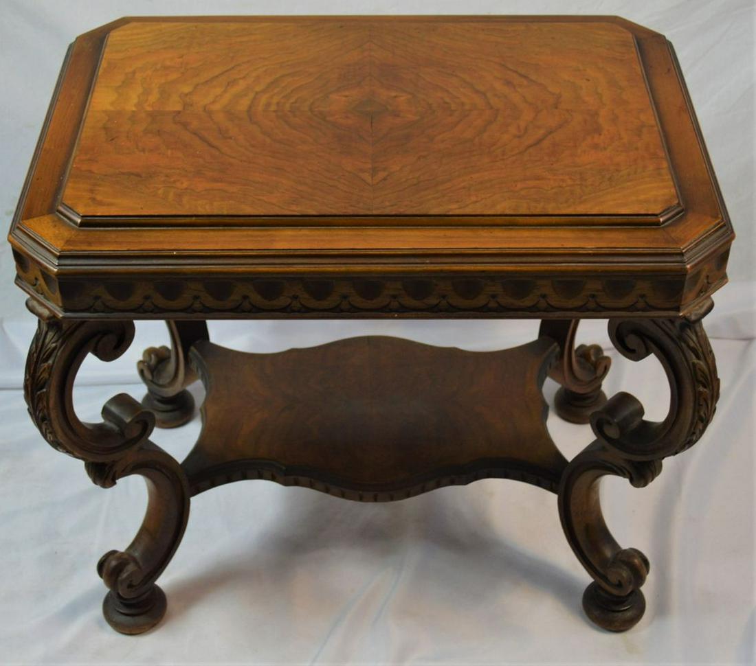 ANTIQUE CARVED MAHOGANY SIDE TABLE: An antique, carved mahogany, two-level side table with pad feet. The top is book-matched inlaid mahogany veneer. There are no visible maker's marks Measures. H: 22 1/2'' X L: 26 1/2'' X D: 18 1/2'' Pr