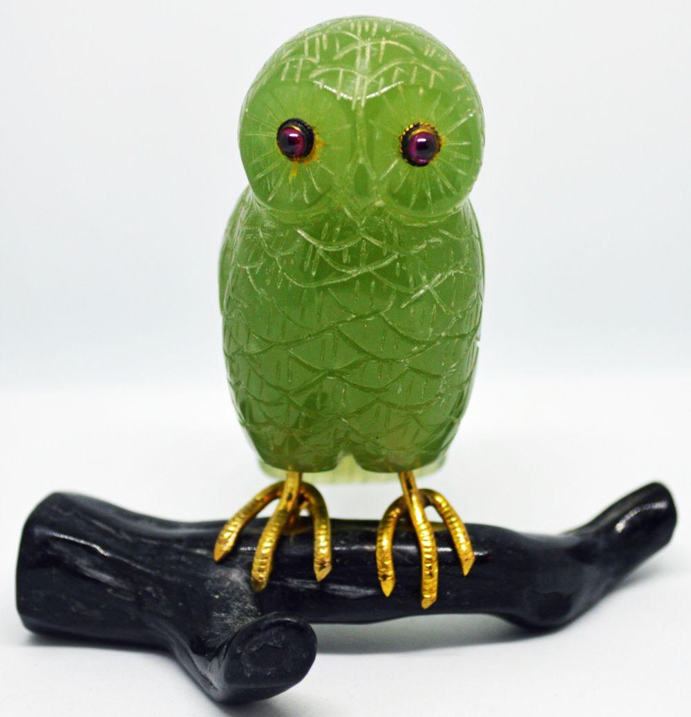 MINIATURE JADEITE OWL & BRANCH SCULPTURE: An appealing jadeite sculptural owl with amethyst colored eyes, gold tone feet grasping a black onyx-like branch. Measures: H: 3'' X W: 3''