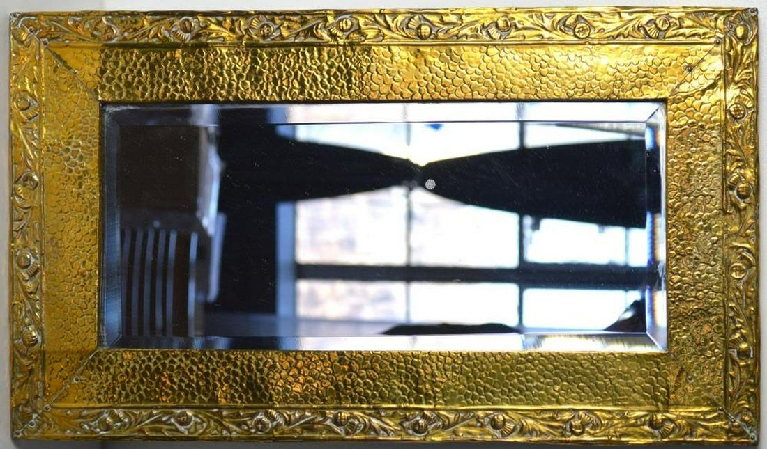 ANTIQUE HAMMERED GOLD TONE MIRROR: An antique hammered relief gold tone metal mirror. Likely 1st/2nd Q 20th C. Measures: 21 1/4" x 12 1/4" Note: Obtained in UK.