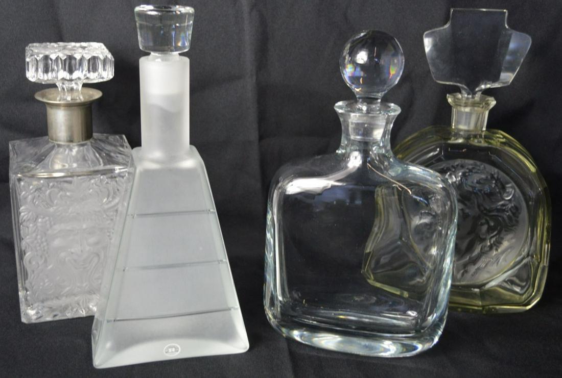 4 CRYSTAL DECANTERS INC DAUM AND REIJMYRE: A lot of 4 crystal decanters. One signed Daum France (decanter w spherical stopper), one labelled Reijmyre Sweden. Measures: Largest H 10 1/2" x W 4 1/2" x D 2