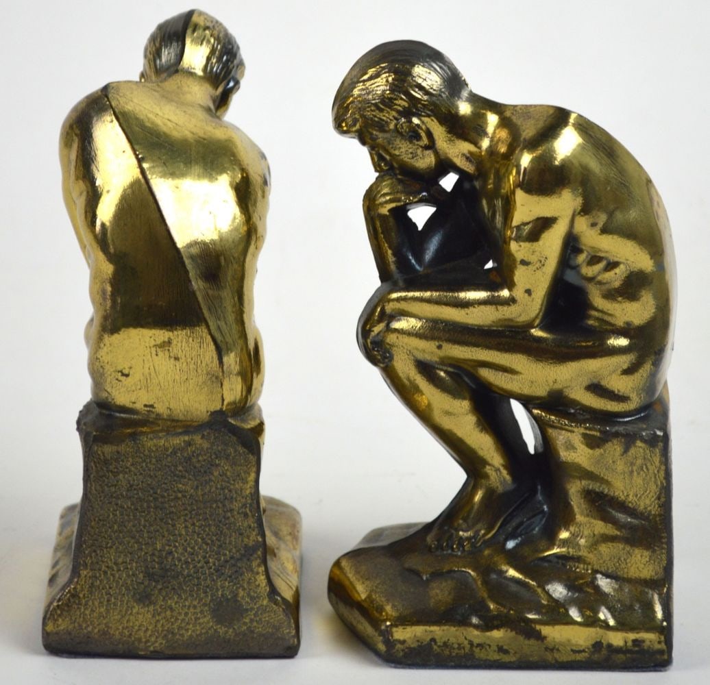 NUDE FIGURAL CAST BOOK ENDS PAIR: A pair of golden bronze patinated metal bookends of a nude male figures. Appealing bookshelf additions. Measures: H 7" x W 4" x D 3"