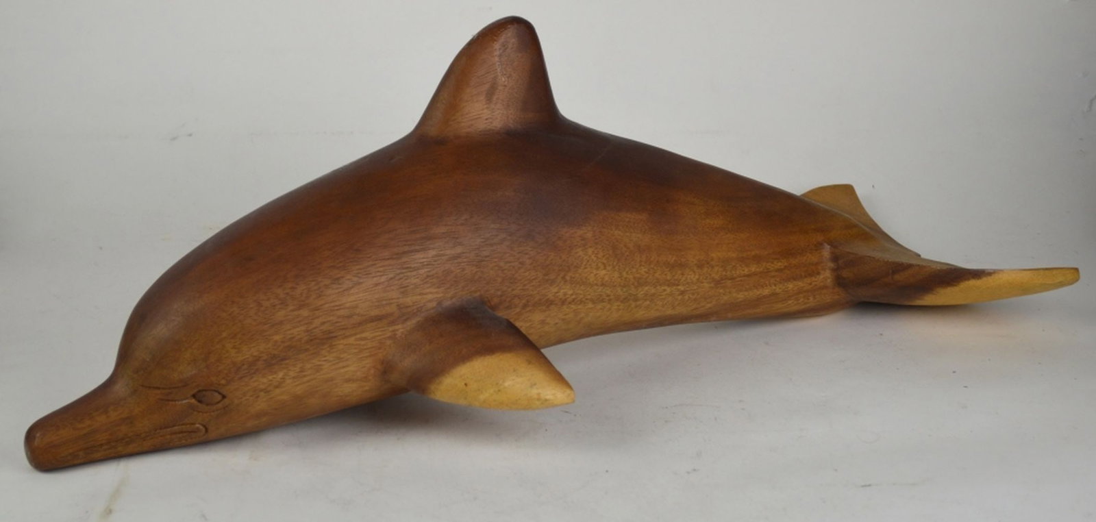 LARGE CARVED WOOD DOLPHIN SCULPTURE: A large carved wood (appears to be teak) dolphin sculpture. The work is not visibly signed. Measures: 26" x 10" x 9"