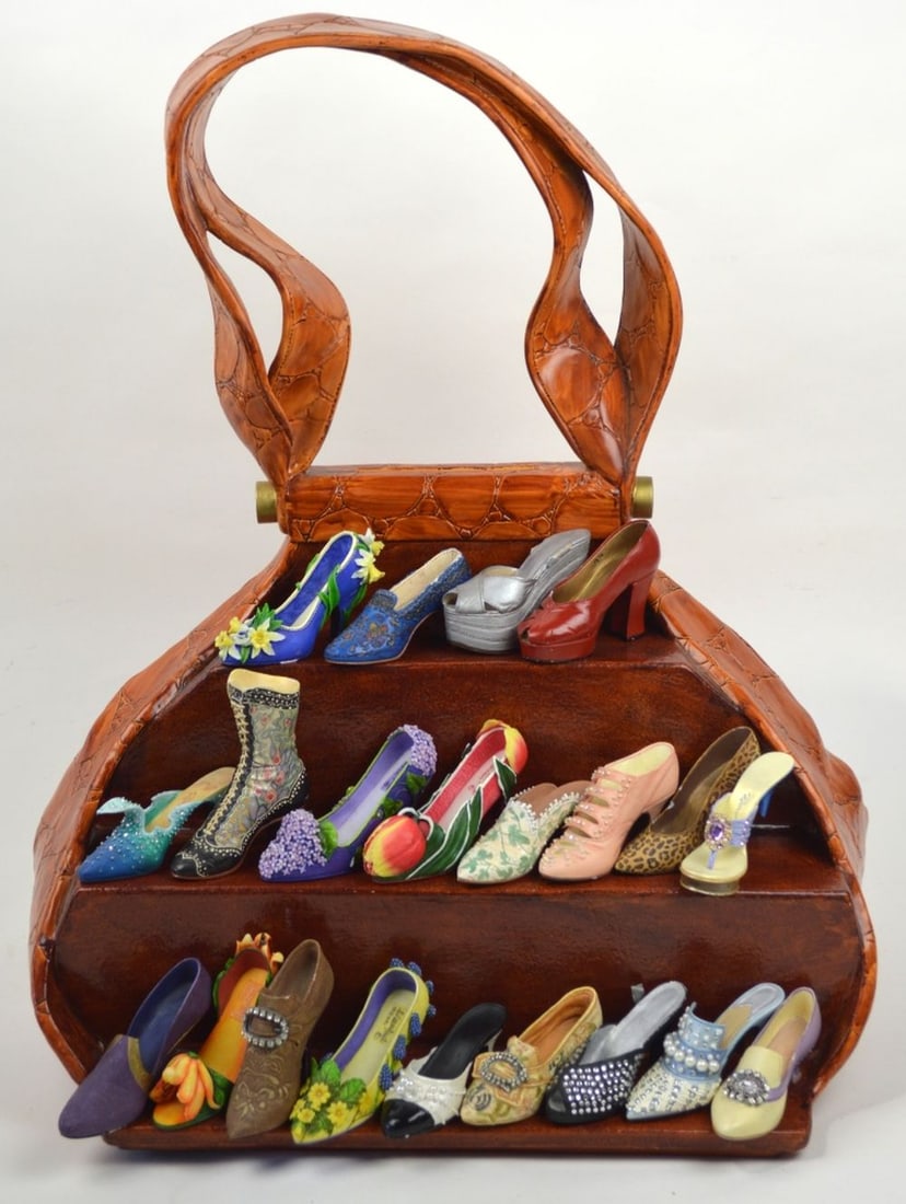 JUST THE RIGHT SHOE DISPLAY AND RAINE SHOES: A Just the Right Shoe (shoes by Raine and others) purse style display (2 pieces) and a collection of accompanying collectible shoes (24 shoes). Measures: H 11 1/2" X W 19 1/2" X D 13"