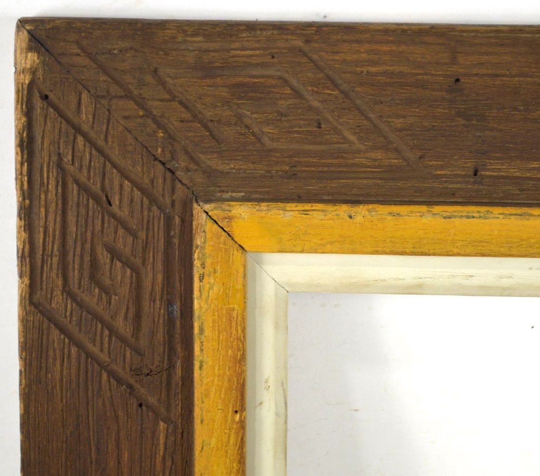 AMERICAN PRIMITIVE HEYDENRYK CHESTNUT FRAME: A finely carved American "primitive" modernist frame by Heydenryk. Slightly angled wide panel exterior presenting Native American / Aztec type carved detail and offset by a raised mustard inner boarde