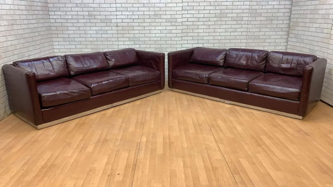Mid Century Modern Ward Bennett Style Parlor Sofas on Chrome Bases in Original Burgundy Leather -: A pair of vintage mid century modern sofas in original burgundy leather on flat bar chrome frame base. Dimensions: H: 27.5” W: 87” D: 34.5” Seat H 17” Seat D 22.5”