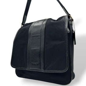 Coach Heritage flap messenger shoulder bag in black, nylon and leather with logo tag. Available for
