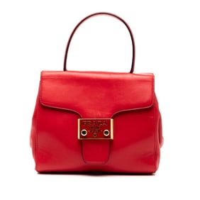 Prada logo plate handbag in red leather for women.