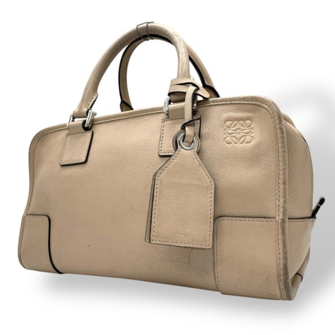 LOEWE Amazona Mini Boston Handbag in Beige Leather with Silver Hardware and Anagram, C8: --- Catalog ---Category: SizeSize (HxWxD): 17cm x 29cm x 13cm / 6.69'' x 11.41'' x 5.11''Category: DesignType: HandbagColor: Pink beigeGender: WomenMaterial: Leather Category: GeneralBrand: Loewe--- I