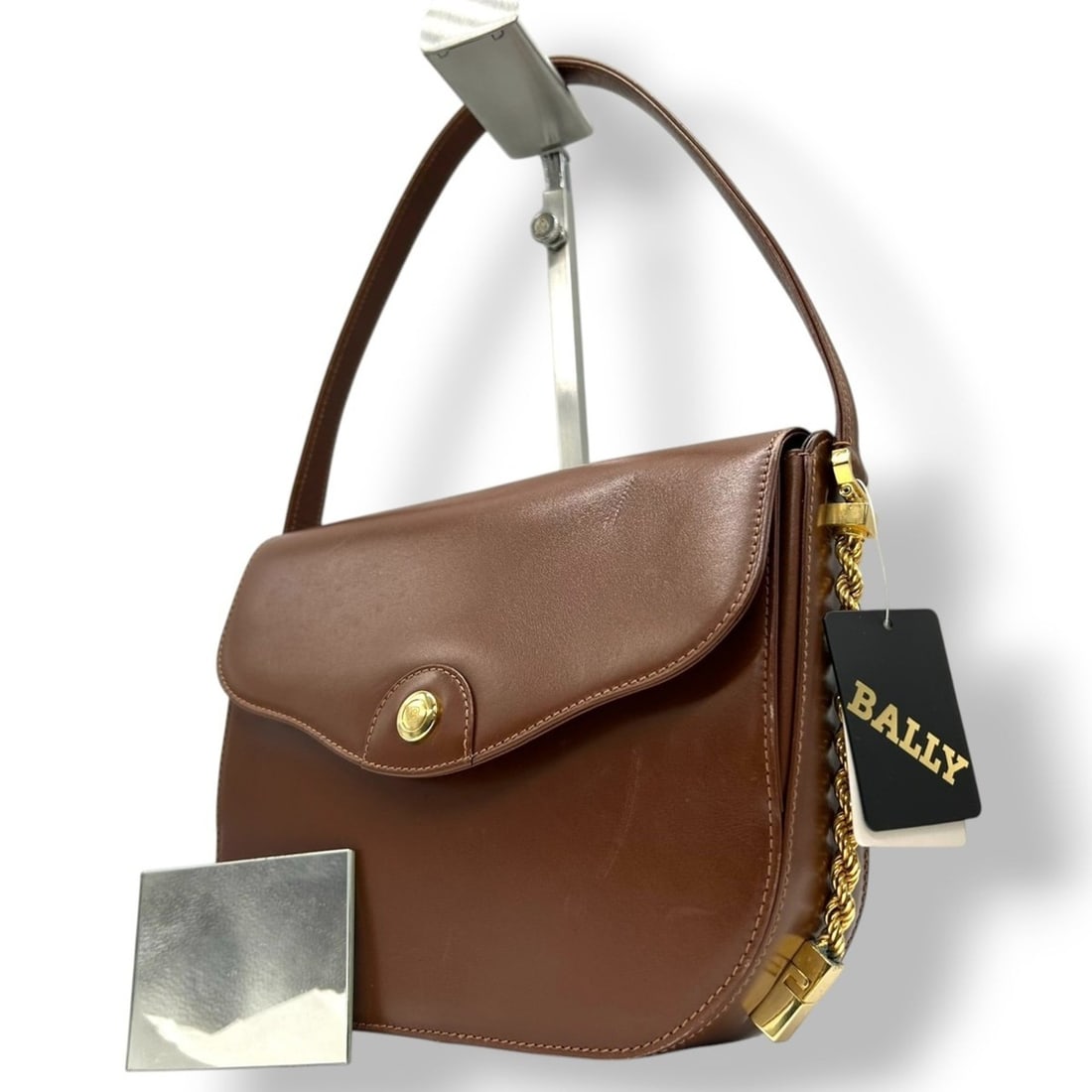 Bally Women's Handbag, Dark Brown Leather with Gold Hardware and Logo Plate, Size s1: --- Catalog ---Category: SizeSize (HxWxD): 18cm x 23cm x 6cm / 7.08'' x 9.05'' x 2.36''Category: DesignType: HandbagColor: Brown, Dark brownGender: WomenMaterial: Leather Category: GeneralBrand: Bally