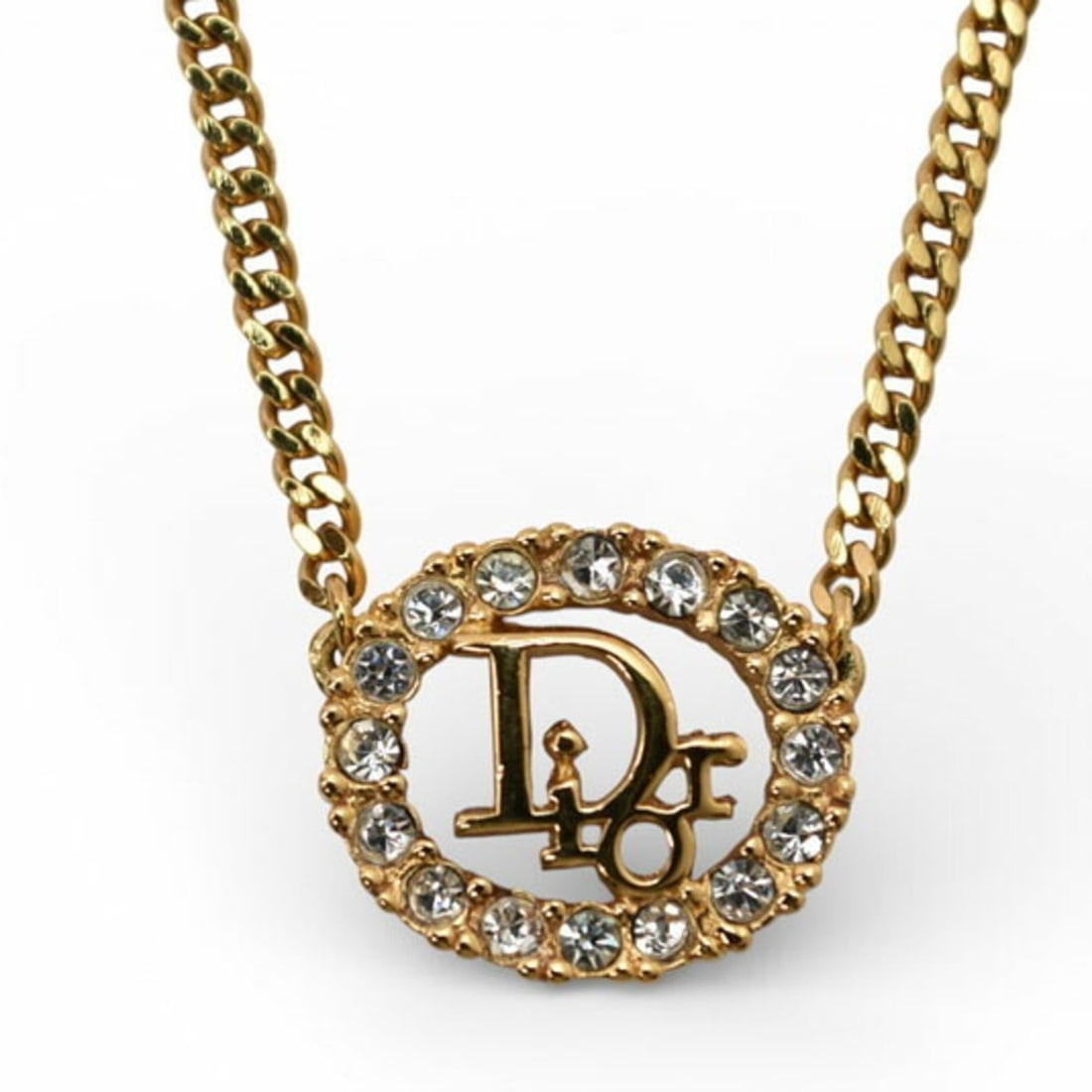 Christian Dior necklace in gold with rhinestones: --- Catalog ---Category: SizeWeight: 8g / 0.28oz.Pendant Size: 13mm x 15mm / 0.51'' x 0.59''Neck Circumference: 37 cm - 42 cm / 14.56'' - 16.53''Category: DesignColor: GoldStone: RhinestoneGender: