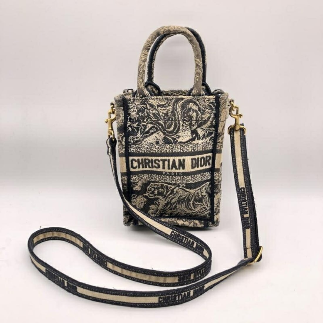 Christian Dior Book Tote Mini Phone Bag 50-MA-0292: --- Catalog ---Category: SizeSize (HxWxD): 17.5cm x 13cm x 7.9cm / 6.88'' x 5.11'' x 3.11''Strap Length: 114cm / 44.88''Category: DesignType: Tote bagGender: WomenCategory: GeneralBrand: Christian
