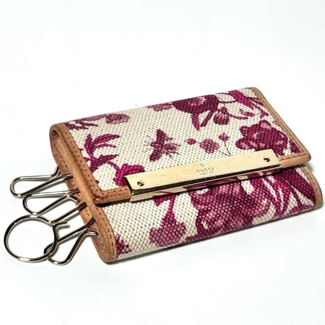 Gucci key case with floral, plant and butterfly motifs, beige, white, purple canvas a natural: --- Catalog ---Category: DesignType: KeycaseColor: Beige, Purple, WhiteMaterial: Canvas , Leather Category: GeneralBrand: GucciCountry of Origin: ItalyCategory: Physical PropertiesSize (HxWxD): 6.5cm