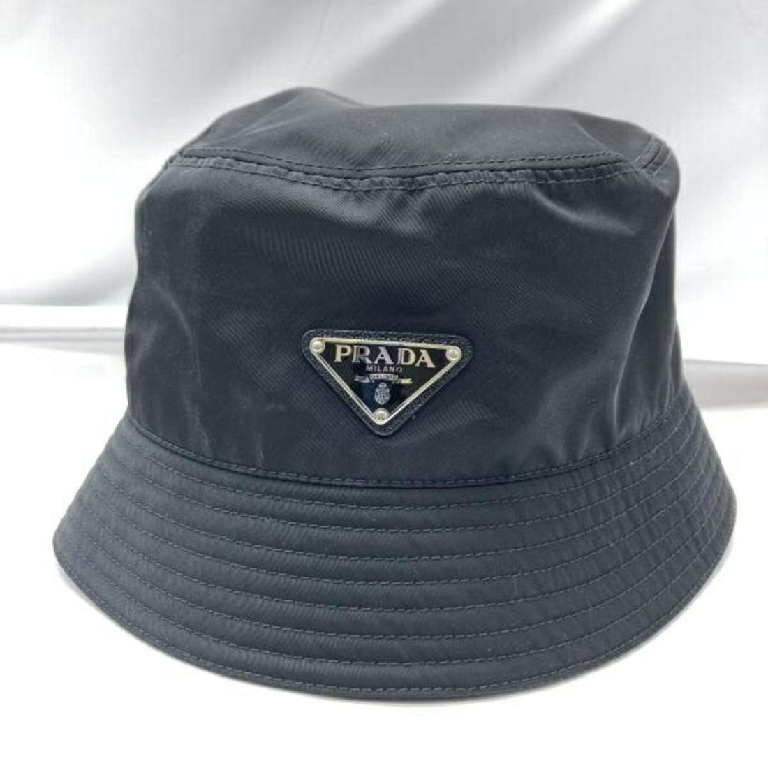 PRADA Bucket Hat, Black, Re-Nylon, 1HC137 2DMI, Size L: --- Catalog ---Category: DesignType: Bucket hatColor: BlackGender: Men,WomenMaterial: Nylon Category: GeneralMPN: 1HC137 2DMIBrand: PradaCategory: MeasurementsCircumference: 57.5cm / 22.63''--- Item