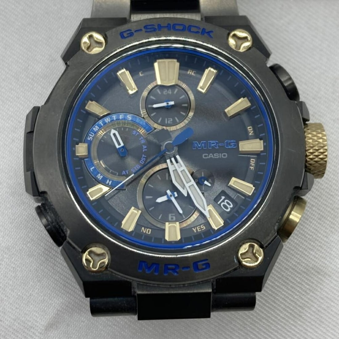 CASIO G-SHOCK MRG-B1000BA-1AJR MR-G Watch, Radio-Controlled Solar, Mobile Link, Black x Blue Gold: --- Catalog ---Category: SizeWrist Size: 16cm / 6.29''Case Diameter: 35mm / 1.38''Category: DesignType: WristwatchColor: Black, GoldGender: MenColor (Dial): BlueCategory: GeneralLine: G-ShockBrand: Ca