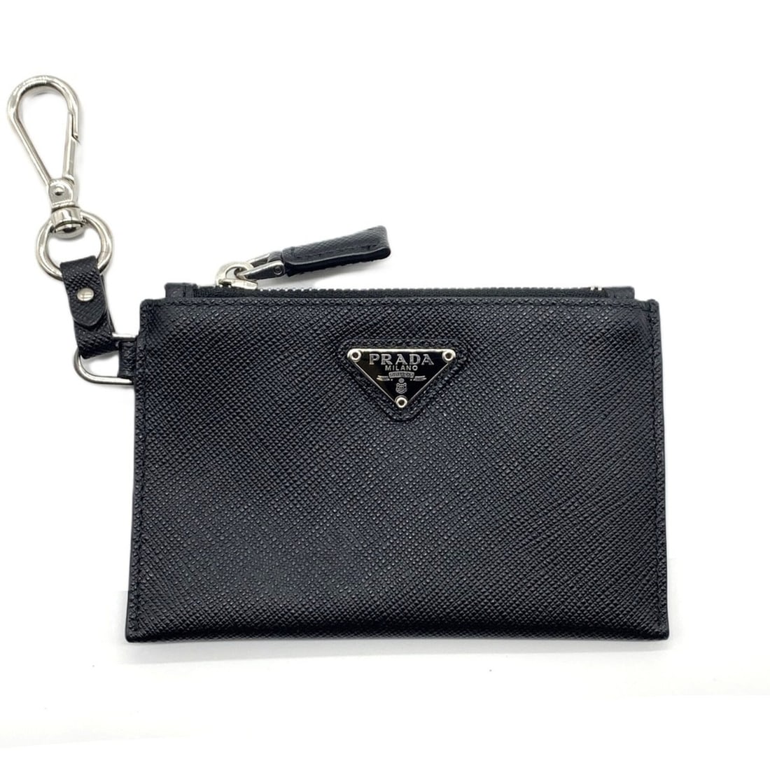 Prada Saffiano Keychain & Coin Case Card Triangle Black PRADA: --- Catalog ---Category: SizeSize (HxWxD): 8cm x 12.5cm / 3.14'' x 4.92''Category: DesignType: Coin purse/coin caseColor: BlackGender: Women,MenMaterial: Saffiano triangle Category: GeneralBrand: