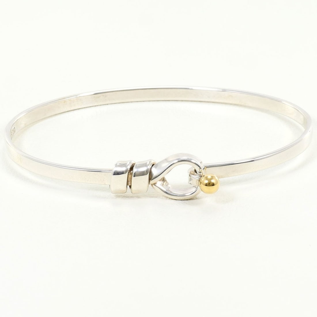 Tiffany & Co. Love Knot Silver 18K Yellow Gold Bangle, Total Weight 12.0g, Like New Condition.: --- Catalog ---Category: SizeLength: 17.5cm / 6.88''Category: DesignType: BangleColor: SilverGender: WomenMaterial: Silver 925, Yellow gold (18K)Category: GeneralBrand: Tiffany--- Item List ---Section