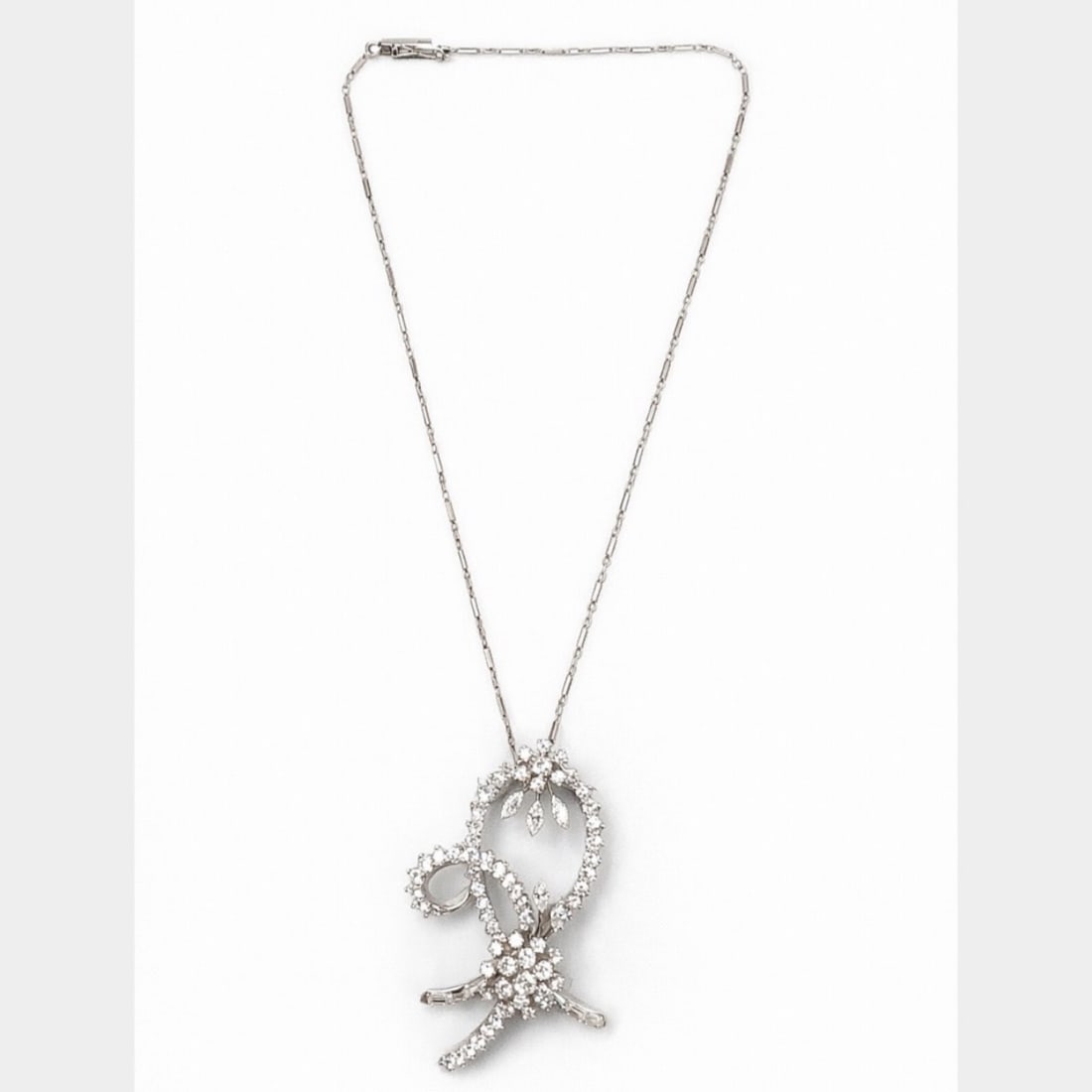 Art Deco Platinum Diamond Brooch/Pendant: Convertible Brooch/Pendant; Art Deco Platinum filigree; Set on a 14K White Gold chain.
