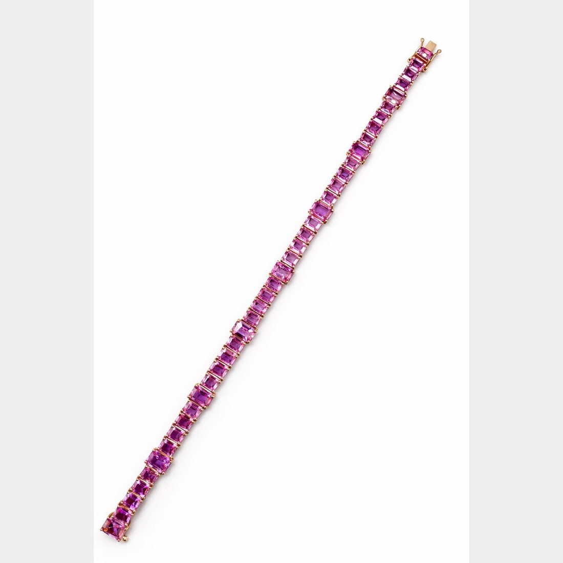 18K YG 26.00 Ct. GIA Pink Sapphire Bracelet: 18K Yellow Gold line setting; Holding 26.00 Ct. of GIA Certified natural Pink Sapphires.