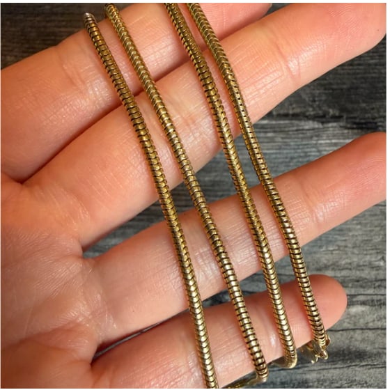 Vintage Tubular Snake Chain in 14K Gold, 24" Long: Exceptionally long, heavy fluid round snake neck chain constructed of tightly linked, seamless seamless circular chevron scales that move like silk. Substantial thickness makes it perfect for heavy st