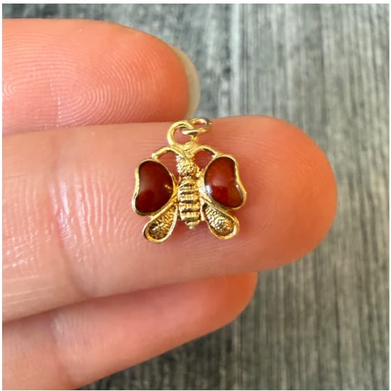 Enamel Butterfly Charm in 14K Gold: Petite cheerful spring insect charm showcasing fine wirework cell matrices filled with hand-painted translucent vitreous yellow and bright orange glass wings over a solid gold back body. Dimensions: 1