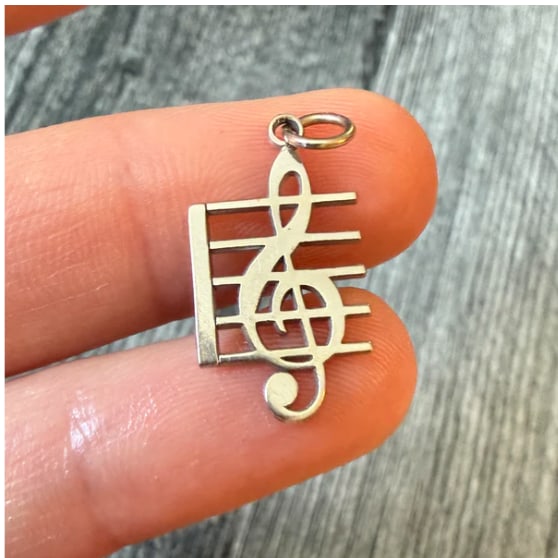 Musical Note Charm in 14K White Gold: Striking modern eighth note/quaver melody charm cleanly stamped out from heavy 14K white gold sheet stock. Mirror-polished front and back faces with straight crisp borders. Dimensions: 15 mm high x 11