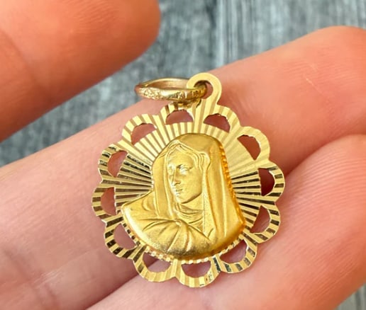 Radiant Reversible Virgin Mary and Jesus Charm in 14K Gold: Dual-sided religious devotional medallion featuring a high-relief profile of Our Lady of Guadalupe on the obverse and the Sacred Heart of Jesus on the reverse, enclosed in a diamond-cut sunburst