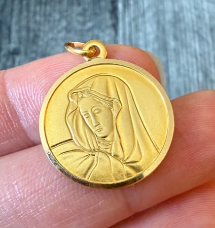 Uno A Erre 18K Gold Virgin Mary Charm: Fine Italian estate religious medal by UnoAErre. Features a deeply sculpted, soft matte portrait bust profile of the Virgin Mary praying, surrounded by a polished structural ring frame. Diameter: 16 m