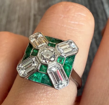 Old Cut Diamond and Calibre Cut Emerald Ring in Platinum: Magnificent Edwardian style target ring featuring a central old European cut sparkling white diamond (approx 0.85 cts, G color, VS1 clarity), surrounded by a concentric circle frame of vibrant rich