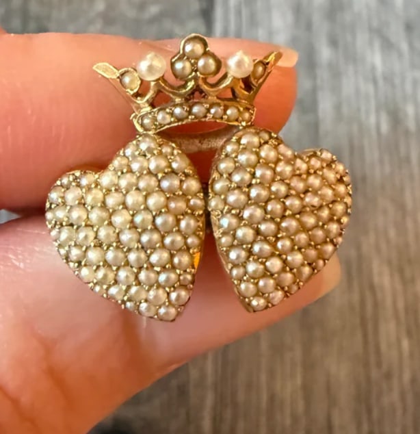 Victorian Pearl and 14K Gold Crowned Hearts Pin: Romantic antique pin showing two interlocking double witch's hearts layered side by side under a shared royal crown motif, completely grain-set with tiny natural white split seed pearls. Dimensions: 2