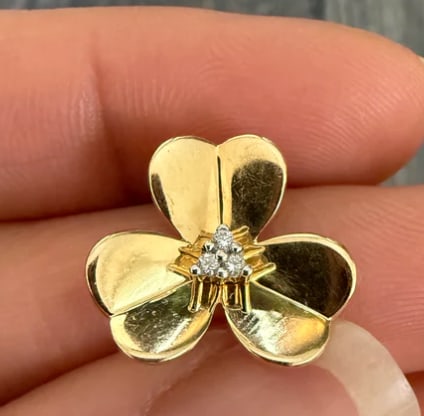 Diamond Trefoil Clover Charm in 14K Gold: Lucky three-leaf trefoil clover leaf charm with a soft satin Florentine surface finish. Centered with an old-mine cut white diamond accent. Dimensions: 14 mm x 14 mm. Weight: 1.9 grams.