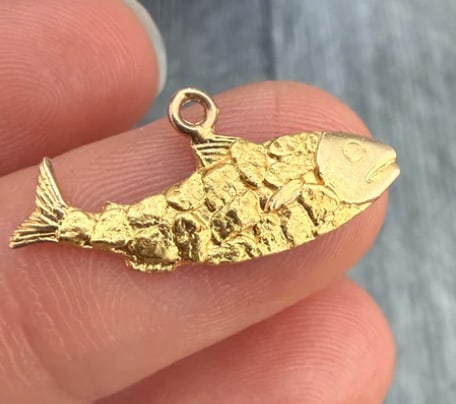 Vintage Alaska Gold Rush Nugget Style 10K Gold Salmon Fish Charm: Souvenir coin charm featuring a highly textural Alaska salmon jumping mid-stream, decorated along its back with inlaid fragments of highly raw, glittering gold rush placer nuggets. Medallion diameter: