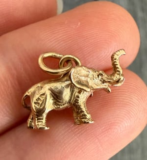 Vintage 14K Gold Elephant Charm (S): Charming three-dimensional hollow trunk-up lucky elephant charm with realistic textured skin details and polished accent blankets. Crafted in solid 14K yellow gold. Measures 15 mm x 12 mm. Weight: 1.9